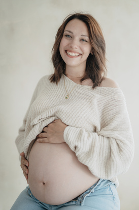 Babybauch im fließenden Kleid fotografiert